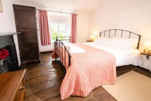 a bedroom with a large bed and a fireplace at Pye Howe in Ambleside