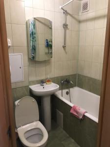a bathroom with a toilet and a sink and a tub at Studio on Vandy Vasylevskoi 8 in Kyiv