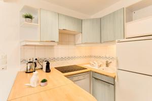 una cucina con armadietti bianchi e frigorifero bianco di Villa Pasteur - Apartment for 4 pers by the Lake ad Annecy