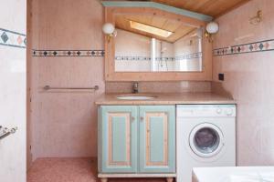 a bathroom with a washing machine and a sink at Cèsa MeSa in Canazei