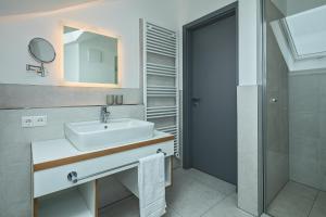 ein Badezimmer mit Waschbecken, Dusche und Spiegel in der Unterkunft Upstalsboom Residenzen Trassenheide in Trassenheide + 34 Fotos