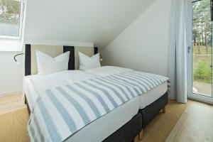 Ein Bett oder Betten in einem Zimmer der Unterkunft Upstalsboom Residenzen Trassenheide