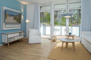 ein Wohnzimmer mit einer Couch und einem Tisch in der Unterkunft Upstalsboom Residenzen Trassenheide in Trassenheide