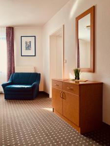 a living room with a blue couch and a mirror at Akzent Congresshotel Hoyerswerda in Hoyerswerda