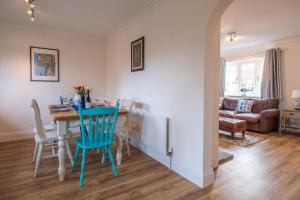 uma cozinha e sala de jantar com mesa e cadeiras em April Cottage em Aldeburgh