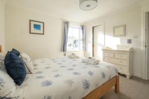 um quarto com uma cama e uma cómoda em April Cottage em Aldeburgh