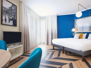 een hotelkamer met een bed en een televisie bij Aparthotel Adagio Porte de Versailles in Parijs