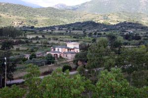 una casa en medio de un valle con montañas en Munduge b&b, en Lotzorai