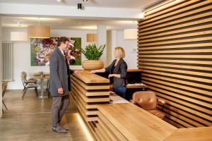 a man and a woman standing at a reception desk at Hotel am Peterstor in Regensburg