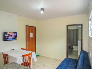 ein Wohnzimmer mit einem Tisch und einem blauen Sofa in der Unterkunft Hospedagem do Peduca in Gamboa