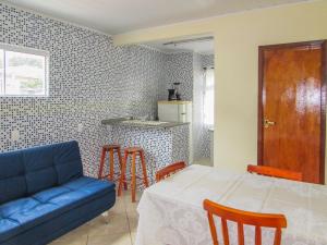 a living room with a blue couch and a table at Hospedagem do Peduca in Gamboa