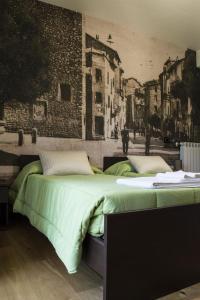 two beds in a room with a painting on the wall at BeB La Passeggiata in Norma