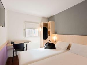 A bed or beds in a room at ibis budget Cannes Centre Ville