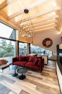 a living room with a red couch and a chandelier at udanypobyt OMG Houses in Kościelisko