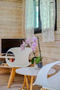 une table blanche avec un vase de fleurs sur elle dans l'établissement Ô Lagon ! Pieds dans l'eau au lagon de l'Ermitage, à Filaos