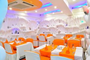 una sala da pranzo con tavoli e sedie e una parete con elefanti di Royal Penguin Boutique Hotel & Spa a Kathmandu