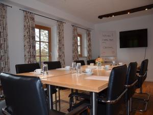 uma sala de conferências com uma grande mesa de madeira e cadeiras em Landhof Angstl - Gästezimmer und Tagungsraum em Höslwang