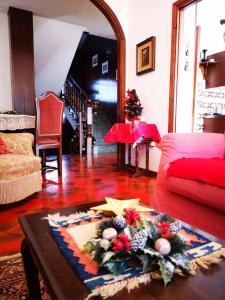 - un salon avec une table et un canapé rouge dans l'établissement Casa Vacanze - Residenza Elvezia, à Tirano
