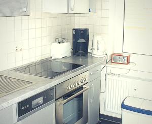 een keuken met een kookplaat, oven en apparatuur bij Villa Silva - Leuchtturmblick in Kühlungsborn