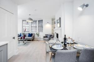 a white living room with a dining table and chairs at Kula London - Covent Garden St Martin's Lane in London
