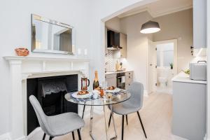 a dining room with a table and chairs and a fireplace at Stay Kula London - Covent Garden St Martin's Lane in London