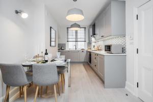 a kitchen with a dining room table and chairs at Stay Kula London - Covent Garden St Martin's Lane in London
