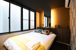 una camera da letto con un letto e ampie finestre di Noyado Uehonmachi ad Osaka