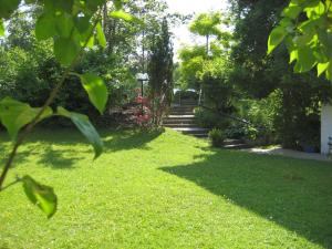 un jardin avec des escaliers, de la pelouse verdoyante et des arbres dans l'établissement Haus an der Therme, à Bad Endorf
