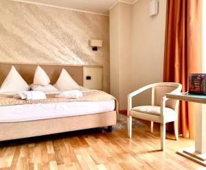 
a bedroom with a bed, chair and a lamp at Hotel Paradis in Cluj-Napoca
