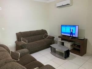 a living room with a couch and a flat screen tv at Apartamento em Praia dos Ingleses in Florianópolis