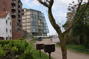 ein Gebäude mitten in einer Stadt mit einem Baum in der Unterkunft De Las Artes XII - triplex sólo familias in Pinamar