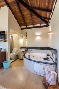 a large bathroom with a tub and two toilets at Villa Severina in Brumadinho