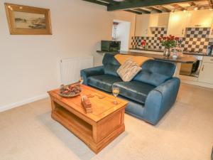 a living room with a blue couch and a coffee table at 3 Eden Lodge in Kirkby Stephen