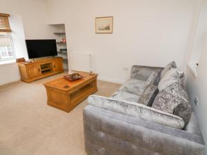a living room with a couch and a television at 2 Eden Lodge in Kirkby Stephen