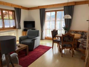 a living room with a chair and a table at Haus Am Wiesbach in Reit im Winkl