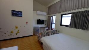 a hotel room with a bed and a tv at 三義竺夢園 漫步山林 漫遊桐花 in Sanyi