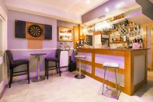 um bar com paredes roxas e bancos de bar em Hotel Mj Kingsway, Cleethorpes Seafront em Cleethorpes