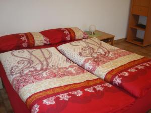 a bed with red and white blankets on top of it at Ferienwohnung Glückstein in Großeibstadt