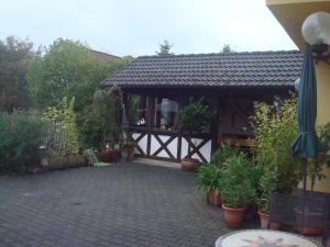 a pavilion in a garden with potted plants at Ferienwohnung Glückstein in Großeibstadt
