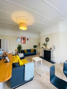 ein Wohnzimmer mit einem blauen Sofa und einem Tisch in der Unterkunft Elegant Spacious Apartment in Heart of St Leonards in Hastings