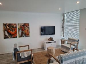 a living room with a flat screen tv on a wall at Point Village Accommodation - Santos 23 in Mossel Bay