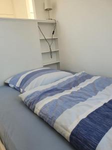 uma cama com um cobertor azul e branco em südausgerichtetes Apartment SüdWest Kleinmachnow em Kleinmachnow