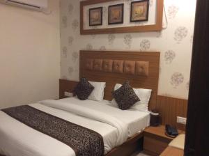 a bedroom with a large bed with white sheets and pillows at HOTEL RK PALACE in Ahmedabad