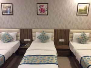a room with two twin beds with blue pillows at HOTEL RK PALACE in Ahmedabad