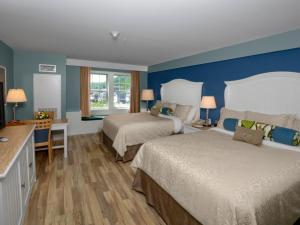 a bedroom with two beds and a blue wall at Watkins Glen Harbor Hotel in Watkins Glen