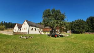 ein großes weißes Haus mit einem Baum auf einem Feld in der Unterkunft Ferienhaus Buxbaum in Arbesbach