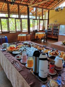 einen langen Tisch mit Speisen und Getränken darauf in der Unterkunft Pousada Colar de Ouro in Cunha