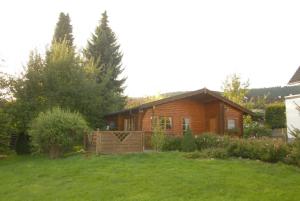 a log cabin in a yard with a yard at Ferienhaus Pöttgen in Arnsberg