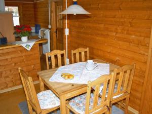 Ferienhaus Pöttgen في أرنسبيرغ: طاولة وكراسي خشبية في غرفة مع طاولة وكرسي
