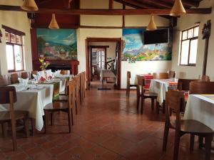 uma sala de jantar com mesas e cadeiras e uma televisão de ecrã plano em Hotel PrincesaToa em Quilotoa